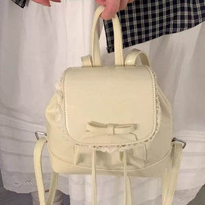 Lace-trimmed bowknot mini backpack in cream with drawstring detail.