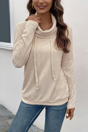 Beige textured knit sweater with cowl neck and drawstring detail.