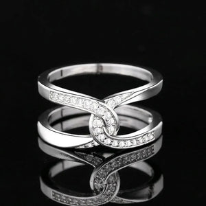 Silver pavé band ring with intertwined design.