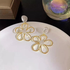 Gold floral drop earrings with pearl accents and a clear bead top.