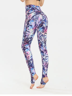 Prism Palm stirrup leggings in dark blue with a colorful floral print and black trim.