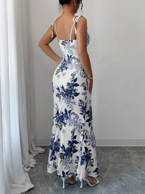 Maxi dress in white with blue floral print, tie straps, and a flared hem.