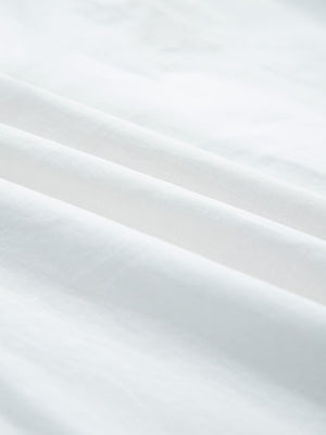 White cotton eyelet embroidered sheer shirt with button-down detail.