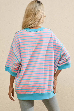 Oversized blush pink sweatshirt with blue stripes, crew neck, and short sleeves.