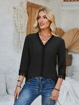 Black eyelet trimmed V-neck blouse with lace detail on neckline and sleeves