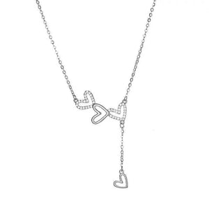 Sterling silver Y-necklace with three heart charms, two adorned with stones.