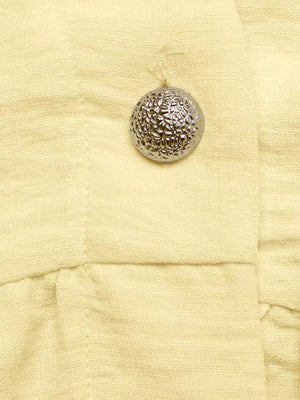 Yellow peplum hem two-piece set detail with textured silver button.