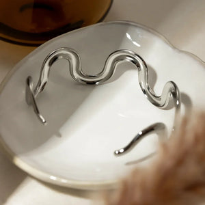 Sculptural silver cuff bracelet with a wavy ripple design.
