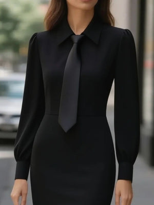 Black tie-neck long sleeve dress with buttoned collar and puff sleeves.
