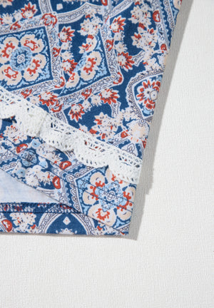 Bohemian print blouse in dusty blue with white lace trim and bell sleeves.