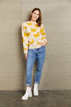 Apricot knit crewneck sweater with allover yellow butterfly motif and crew neckline.