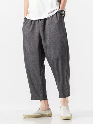 Men's dark gray relaxed fit cropped sweatpants with drawstring waist and pockets.