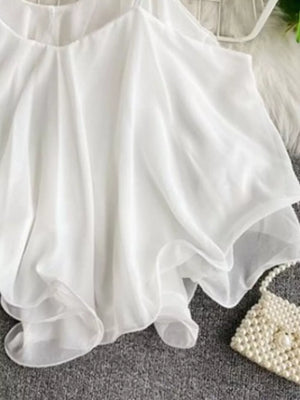White ruffled camisole with spaghetti straps and delicate sheer layers.