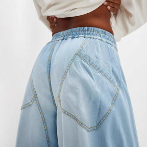 Light blue denim jeans with elastic waistband and unique pocket stitching detail.