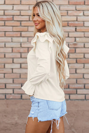 Textured ruffle sleeve blouse in eggshell with cinched cuffs.