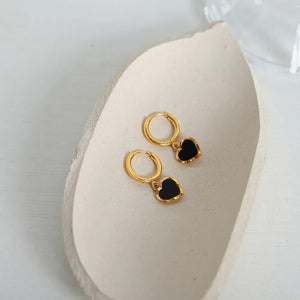 Gold hoop earrings with black enamel heart charms