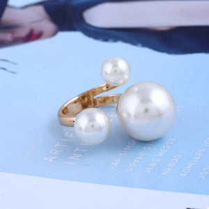 Elegant gold-plated open ring with three pearls of varying sizes.