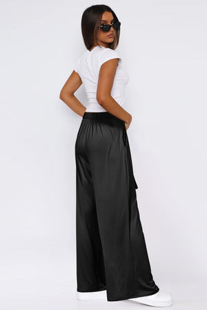 Black satin palazzo trousers with a tie waist and wide legs.