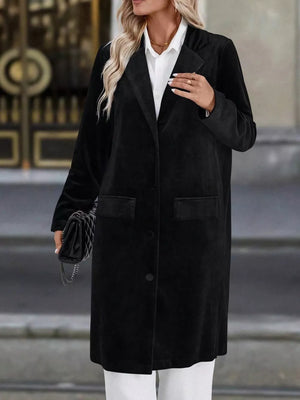 Black longline trench coat with lapel collar, buttoned front and flap pockets.