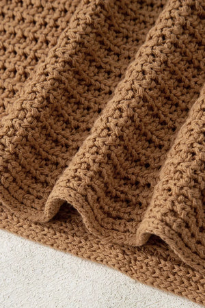 Textured brown knit pullover sweater with wide bell sleeves and a chunky knit pattern.