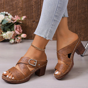 Brown laser-cut criss-cross block heel sandals with buckle detail.