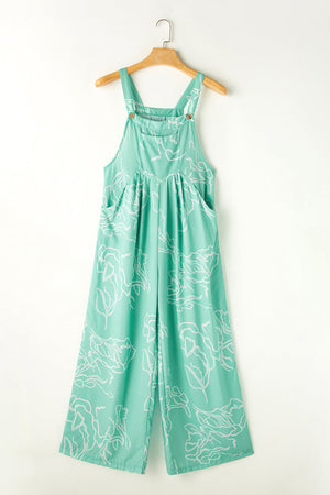 Turquoise botanical print wide-leg jumpsuit with pockets and adjustable straps.