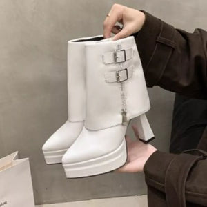 White platform ankle boots with pointed toe, block heel, buckle straps and zipper detail.