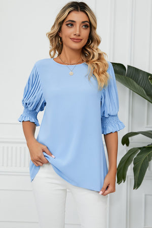 Light blue blouse with pleated sleeves and smocked cuffs