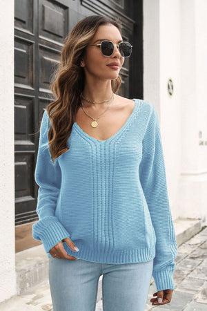 Light blue acrylic V-neck sweater with vertical ribbing detail and long sleeves.
