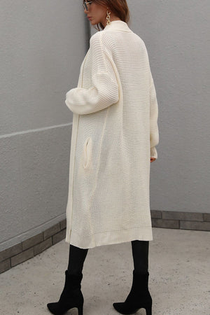 Cream textured knit maxi cardigan with pockets and a relaxed fit.