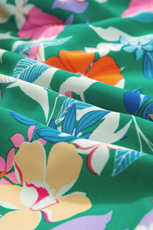 Dark green midi dress with a vibrant floral print and ruffled sleeves.