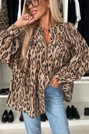 Caramel leopard print blouse with balloon sleeves and button front, styled with jeans.