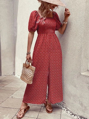 Red floral smocked bodice puff sleeve wide-leg jumpsuit with a square neckline and front slit.