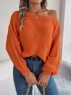 Orange off-the-shoulder knit sweater with openwork detail and long sleeves.