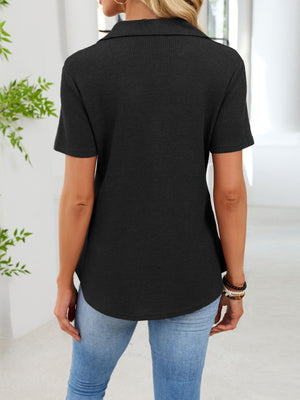 Black waffle knit button placket t-shirt with collared neckline and short sleeves.