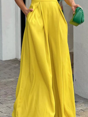 Canary yellow cinched waist romper with deep v-neck and puff sleeves.