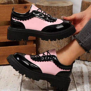 Pink and black patent leather round toe platform loafers with brogue detailing and scalloped trim.