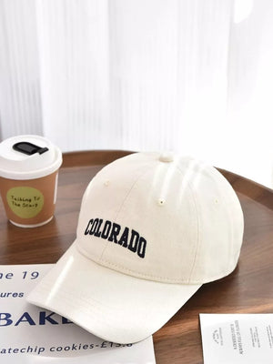 Beige cotton baseball cap with embroidered black "COLORADO" text.