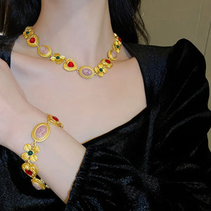 Gold cameo and floral statement necklace with red and green accents
