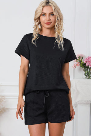 Black quilted tee and shorts set with geometric pattern and drawstring waist.