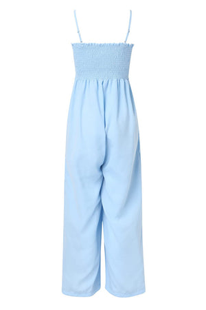 Light blue smocked bodice palazzo jumpsuit with adjustable spaghetti straps and wide legs.