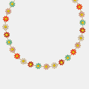 Daisy chain collar necklace with colorful enamel flowers on a gold chain.