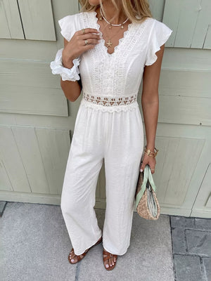 White lace-trimmed wide-leg romper with flutter sleeves and cutout waist detail.