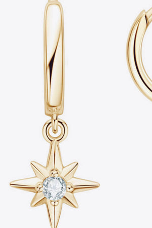 Gold hoop earrings with a dangling star charm featuring a clear gem accent.