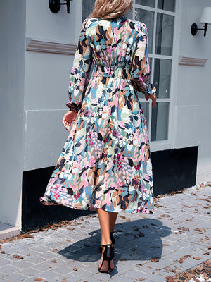 Floral print midi dress with V-neck, long sleeves, and tiered skirt in beige.