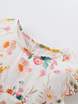 Toddler dress with watercolor floral print, ruffle sleeves, and round neckline.