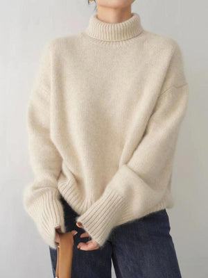 Cream cashmere turtleneck sweater with relaxed fit and ribbed cuffs.