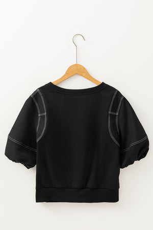 Black blouse with contrast stitching, puff sleeves, and a crew neck.
