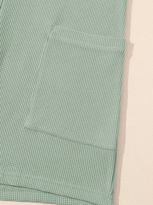 Sage waffle knit button-down romper with a chest pocket detail.