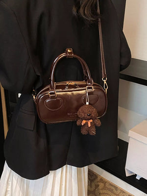 Chic mini crossbody bag in chocolate PU leather with teddy bear charm.